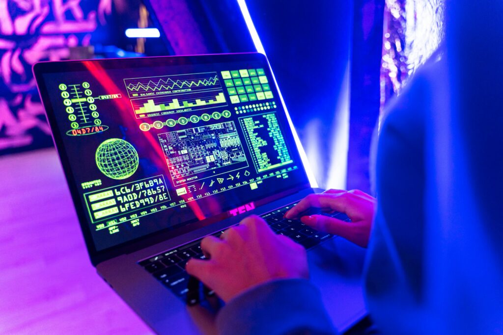 Person typing on a laptop with vibrant digital data display, highlighting cyber security.